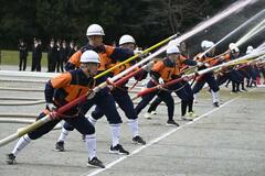 消防車両を点検 空中消火訓練も