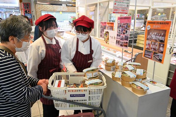 客に弁当の説明をする生徒たち