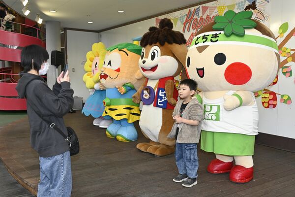 マスコットキャラクターと写真撮影する利用者