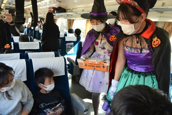 自作のドレスでお菓子を配る生徒ら