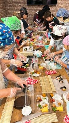 巻き寿司作りに挑戦する親子ら