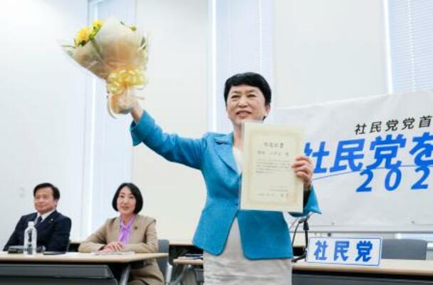 　社民党党首選の決選投票で当選し、笑顔を見せる福島瑞穂党首。奥左からラサール石井副党首、大椿裕子元参院議員＝６日午後、国会