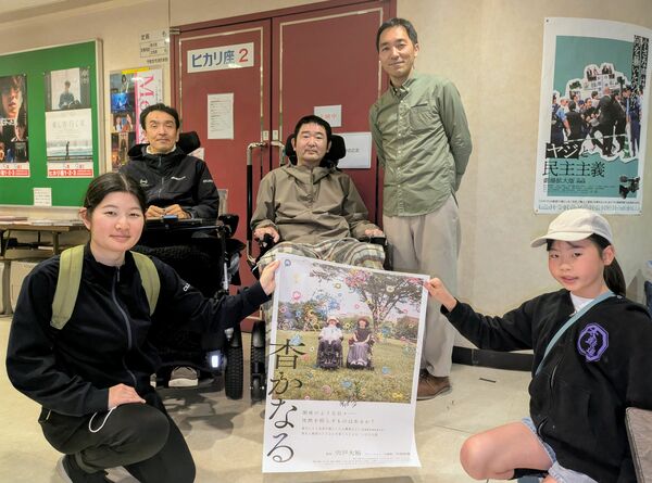 映画のポスターを囲む宍戸監督(後列右端)や鈴木支部長(同中央)たち=27日午後、宇都宮市江野町