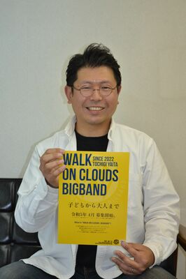 ビッグバンドの参加募集のチラシを手にする益子さん