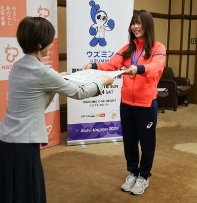 　名古屋市の杉野みどり副市長（左）から「名古屋市スポーツ栄誉賞」の表彰状を受け取る、スノーボード女子の深田茉莉選手＝２０日午後、名古屋市役所