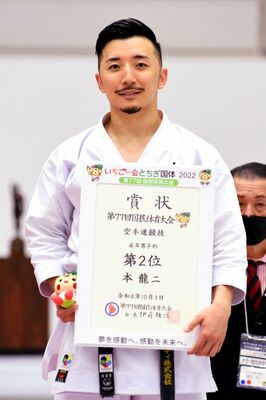 空手道成年男子形で準優勝し、表彰台で笑顔を見せる本龍二（イーギャランティ）＝３日午前１１時２０分、県南体育館