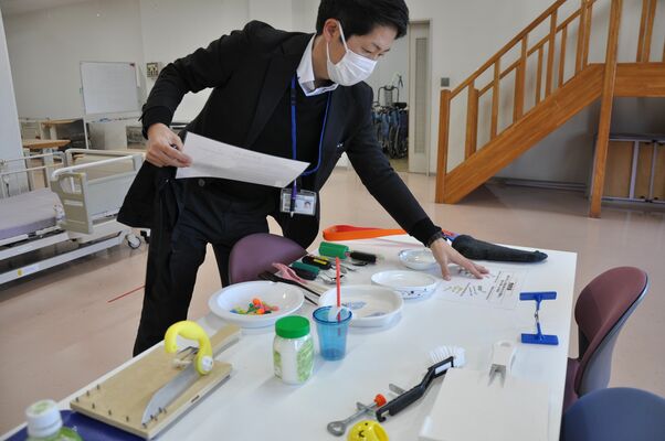 体験会で使用する自助具などを用意する関森准教授
