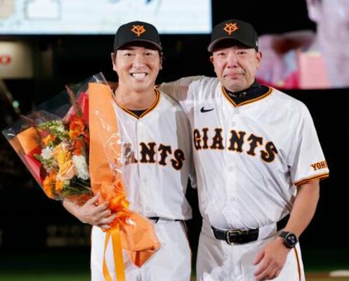 　ファン感謝イベントで行われた引退セレモニーで、阿部監督（右）と写真に納まる巨人・長野＝２３日、東京ドーム