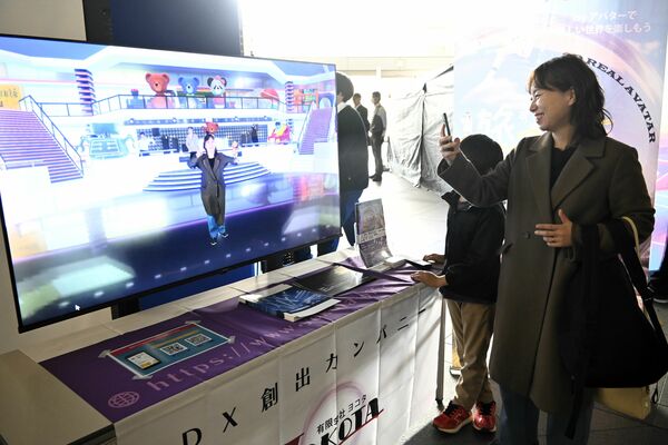 仮想空間に自分のアバターがダンスするのを見て楽しむ来場者＝５日午前、県庁