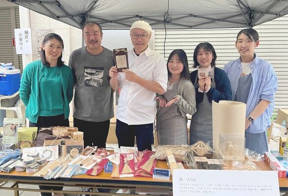 大森さん（左から２人目）や辻口さん（同３人目）と笑顔を見せる産能大の学生
