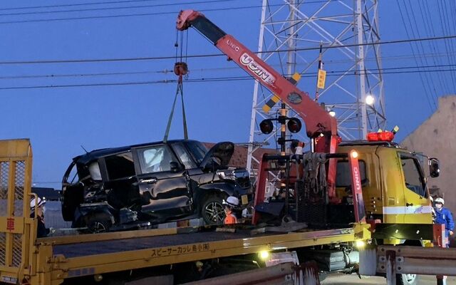 東武伊勢崎線の特急と衝突し、踏切から撤去される車＝25日午後５時20分、足利市福居町