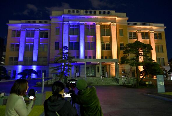 青とオレンジ色にライトアップされた県庁昭和館＝４日午後６時、宇都宮市塙田１丁目