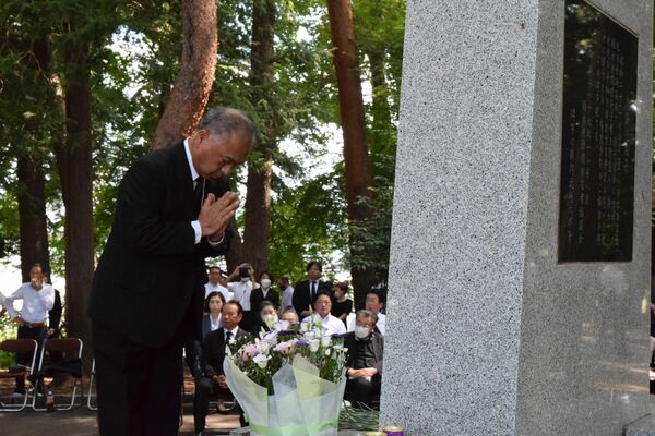 慰霊碑に手を合わせる参列者＝19日午前、宇都宮市西川田４丁目
