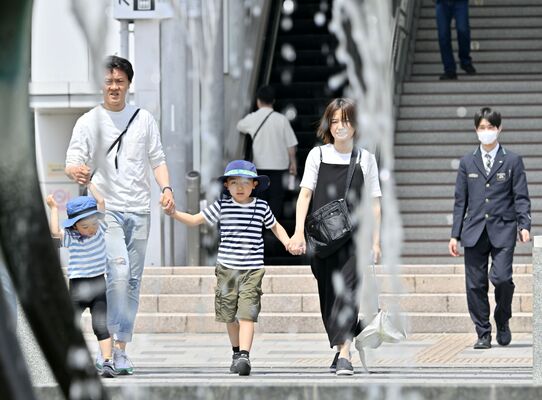 強い日差しの中、半袖姿で歩く人たち＝19日正午、佐野市若松町、森田大地撮影