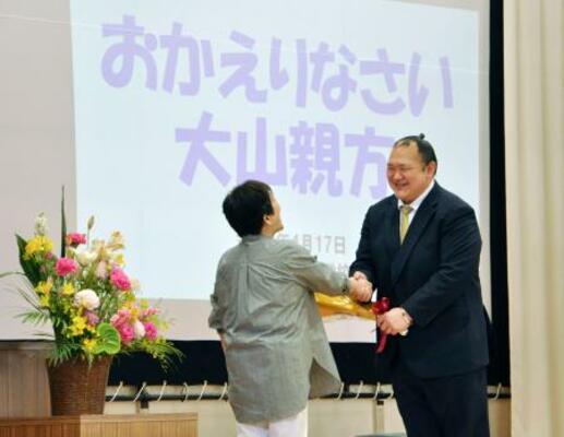 　母校を訪問し、小学６年生の時の担任から花束を受け取る大山親方（右）＝１７日、埼玉県所沢市