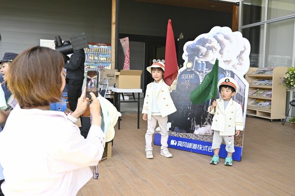 駅長の制服姿で記念撮影を楽しむ親子＝16日午前、宇都宮市インターパーク６丁目