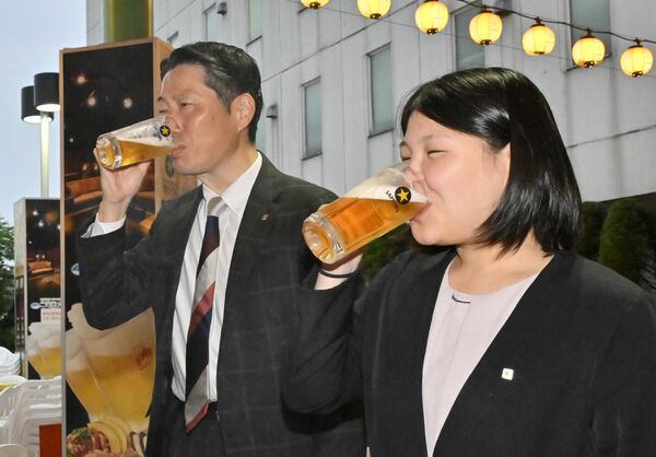 ビールを片手に笑顔で乾杯する会社員ら