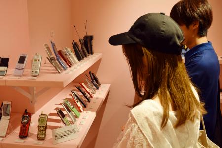 　ＮＥＯ平成レトロ展で「ガラケー」コーナーを見学する来場者＝東京・渋谷
