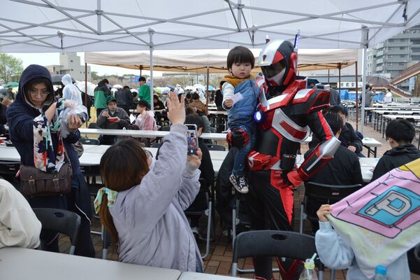 最強ラーメン祭会場で来場者と記念撮影するブレイバーン