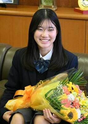 花束を手に笑顔を見せる石原さん