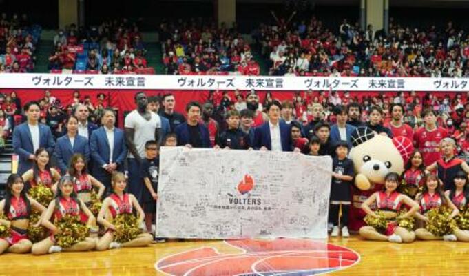 試合後に記念撮影するバスケットボールB2熊本の選手とOBら=12日、熊本県立総合体育館