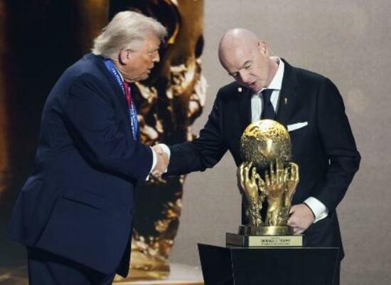 サッカーW杯北中米3カ国大会の組み合わせ抽選会で、トランプ米大統領(左)に「FIFA平和賞」を授与するインファンティノ会長=2025年12月、米ワシントン(共同)