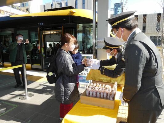 親子連れに記念品を手渡す運転士