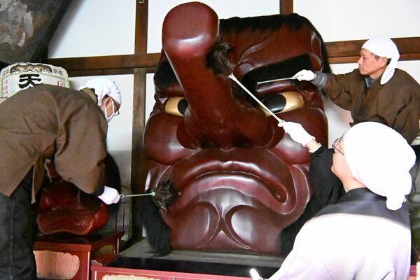 大天狗面のほこりを落とす住職ら