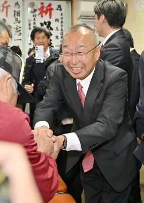 再選を果たし、支持者と握手する相馬憲一氏（右）＝22日午後８時35分、大田原市末広３丁目、磯真奈美撮影