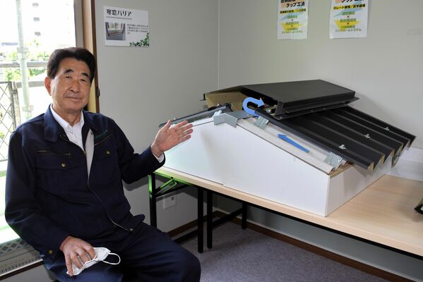 「遮熱鋼板ラップ工法」の構造を説明する野口社長＝足利市