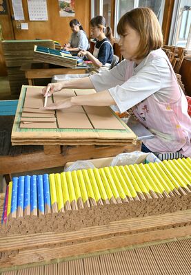 杉線香を木べらで小分けし、束ねる従業員＝27日午後１時45分、日光市小百