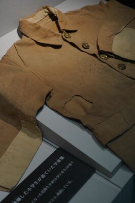 空襲で犠牲になった男児が着ていた学童服。爆弾の破片が体を貫通していたことが分かる＝秋田市土崎みなと歴史伝承館、三浦正基撮影