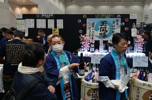 次々に酒を注いでくれる「２０２６にいがた酒の陣」各蔵ブース＝３月８日、新潟市