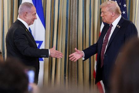 　９月２９日、米ホワイトハウスで共同記者発表の際に握手するトランプ大統領（右）とイスラエルのネタニヤフ首相（ロイター＝共同）