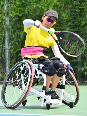 握力の弱い右手にテーピングをしてラケットを握る大谷。シングルス、ダブルスともに金メダルを狙う＝７月、佐賀市