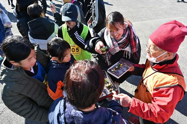 トレイルリレーマラソンで村上さんとドングリを囲む子どもたち
