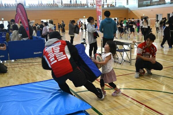 ボールを抱えて思い切りタックルする参加者
