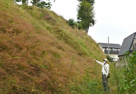 城山公園東側に残る土塁について説明する大島さん