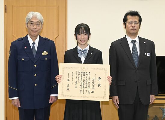 杉本本部長(左)から賞状を受け取った山崎さん(中央)=5日午後、県警本部