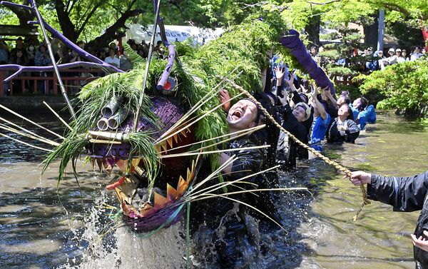 豪快にしぶきを上げる蛇と参加者＝５日午後０時30分、小山市間々田