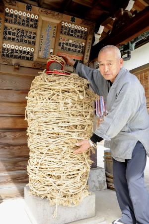 「しばられ地蔵」と住職の日吉聖順さん=東京都葛飾区