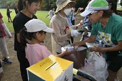 参加の児童にお菓子手渡す
