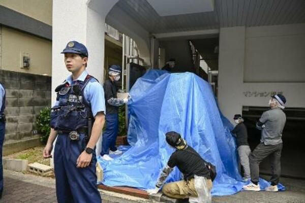男性の遺体が見つかったマンションを捜索する捜査員=21日午後、神戸市中央区