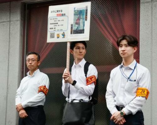 佐藤麻衣さんの事件について、情報提供を求めプラカードを掲げる茨城県警の警察官=5日午後、埼玉県草加市