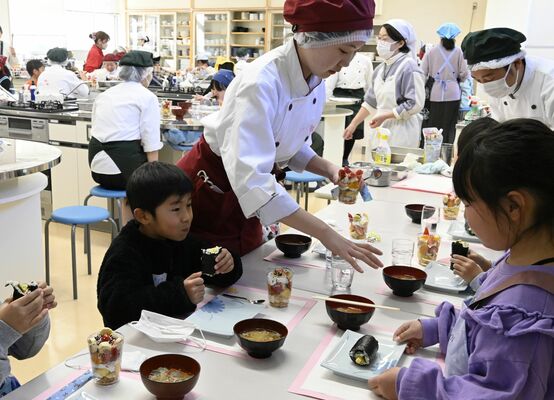 高校生と一緒に調理を体験した後、食事を楽しむ子どもたち