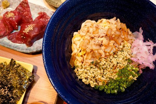 定番メニューの「かまたまうどん」。左上はサイドメニューの「肉寿司」
