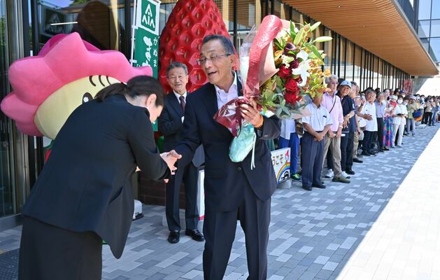 職員や市民らが見送る中、花束を受け取る佐藤市長