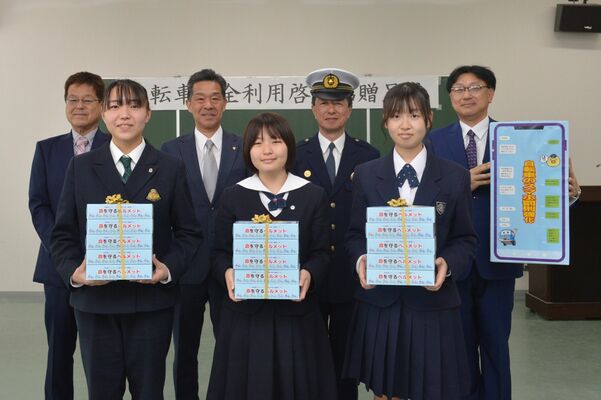 森平署長（後列右から２人目）と県トラック協会宇都宮中央支部員からティッシュを贈呈された高校生