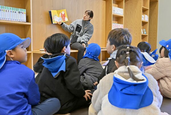 みるるを訪れクリスマスの絵本の読み聞かせに聞き入る園児