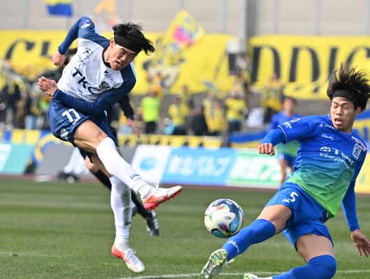 前半、シュートを放つ栃木SCの西野(左)=ソユースタジアム